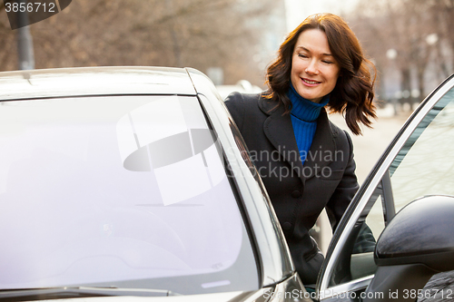 Image of smiling woman opened the car door