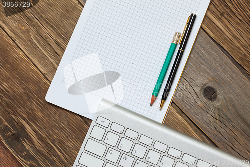 Image of Computer keyboard, notebook and pen