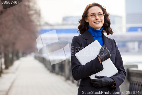 Image of beautiful middle-aged woman wearing glasses with a laptop