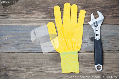 Image of yellow glove and adjustable spanner