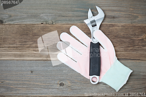 Image of white glove and adjustable spanner