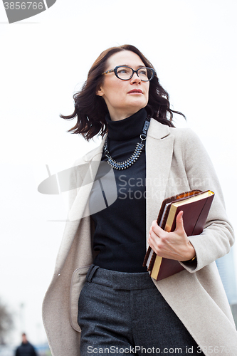 Image of dark-haired middle-aged woman with books