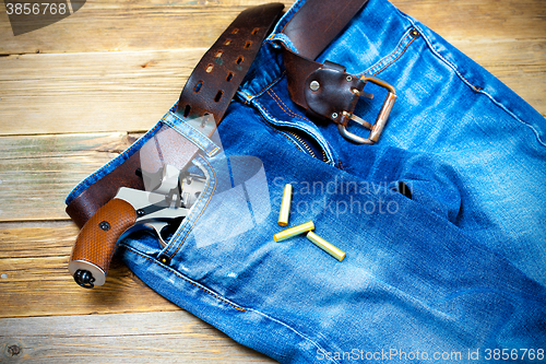 Image of old blue jeans with silver revolver in his pocket