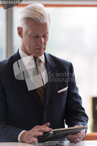 Image of senior business man working on tablet computer