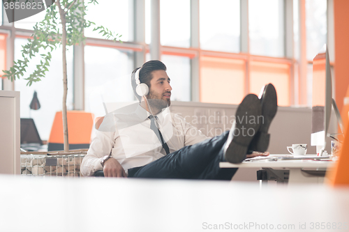 Image of relaxed young business man at office