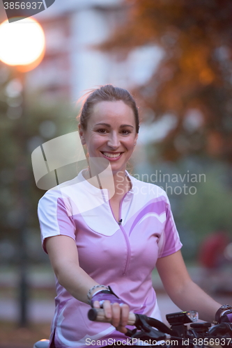 Image of portrait of sporty woman with bike in park