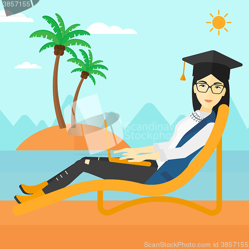 Image of Graduate lying on chaise lounge with laptop.