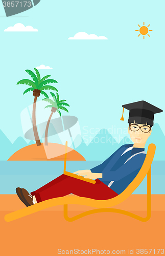 Image of Graduate lying on chaise lounge with laptop.