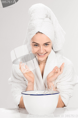 Image of Young woman washing face with clean water