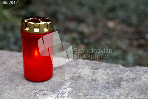 Image of Red candle at a grave 