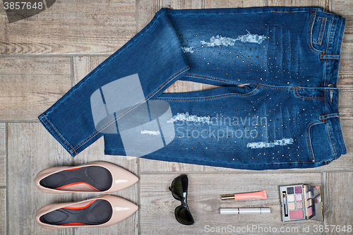 Image of Overhead view of woman\'s jeans and accessories