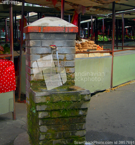 Image of  public water fountain bathing faucet with water running in prod