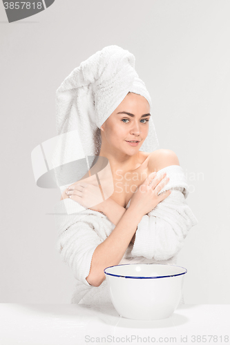 Image of Young woman washing face with clean water