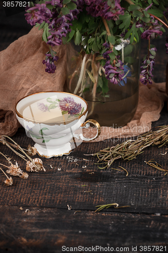 Image of Tea with  lemon and bouquet of primroses on the table