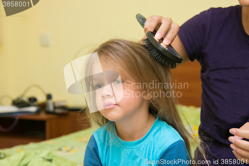 Image of Little girl combing her long hair massage comb