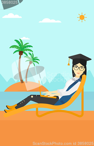 Image of Graduate lying on chaise lounge with laptop.