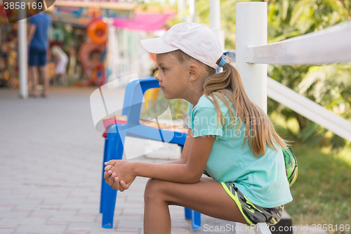 Image of girl six years sitting in the street and waits