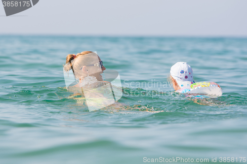 Image of A girl with a child swimming in the sea