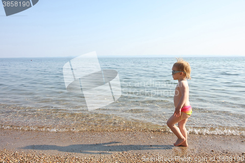 Image of Baby girl walking on the beach sand