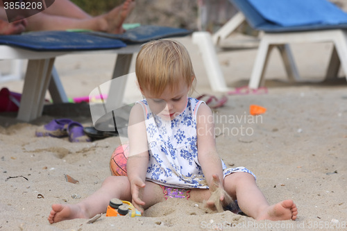 Image of Baby girl playing on the beach