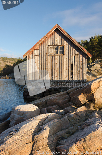 Image of Old boathouse standing betwen the water