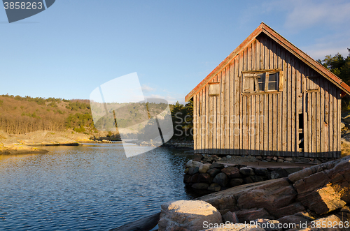 Image of Old boathouse standing betwen the water 