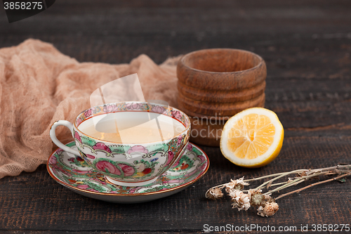 Image of Tea with  lemon and primroses on the table