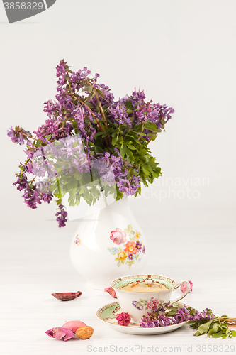 Image of Tea with  lemon and bouquet of  lilac primroses on the table