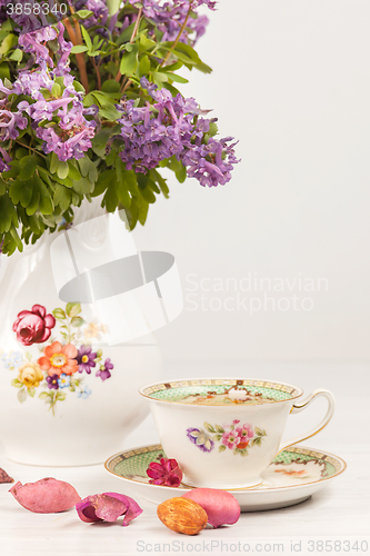 Image of Tea with  lemon and bouquet of  lilac primroses on the table