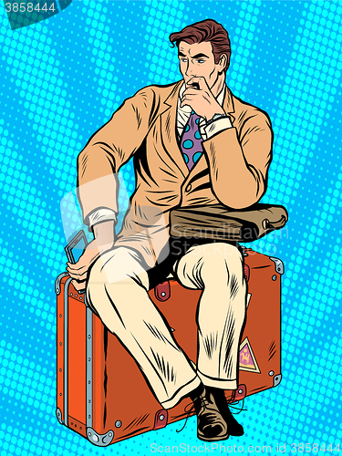Image of Man traveler sitting on a suitcase