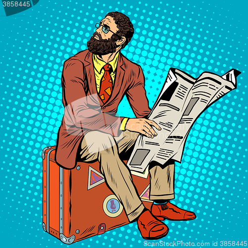 Image of Bearded hipster traveler reading a newspaper