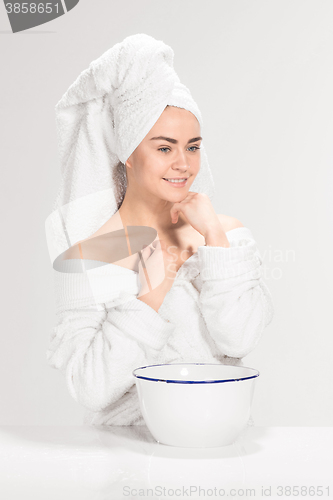 Image of Young woman washing face with clean water