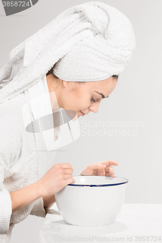 Image of Young woman washing face with clean water