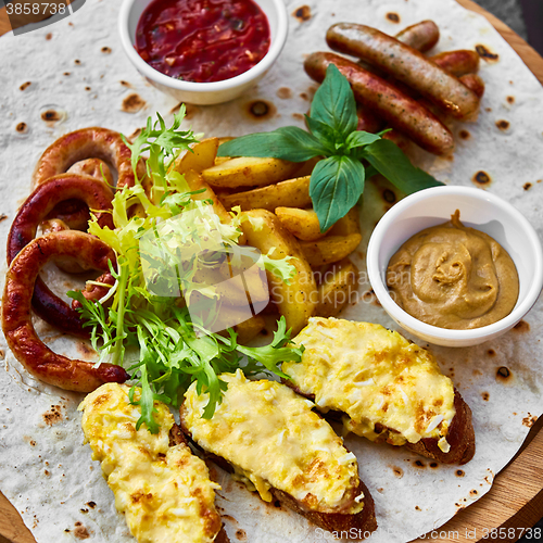 Image of Grilled sausages and vegetables  in rustic style. 