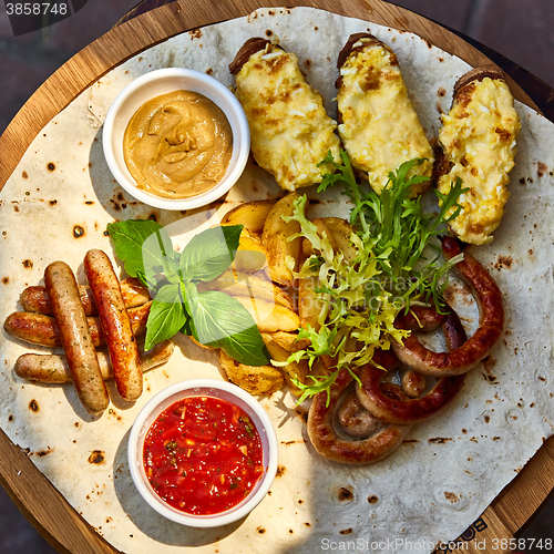Image of Grilled sausages and vegetables  in rustic style. 