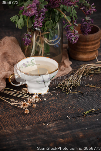 Image of Tea with  lemon and bouquet of primroses on the table