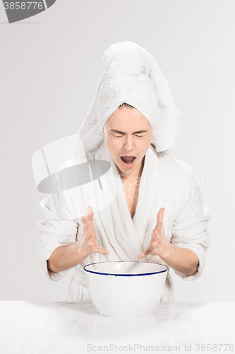 Image of Young woman washing face with clean water