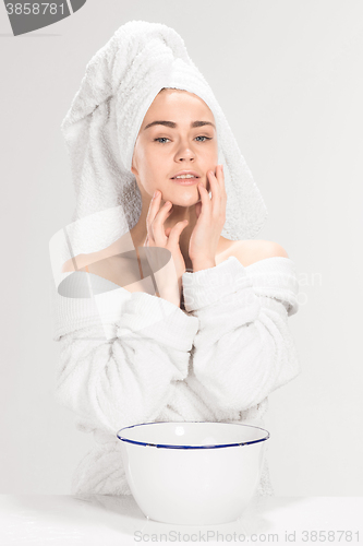 Image of Young woman washing face with clean water