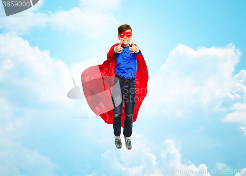 Image of boy in super hero cape and mask showing thumbs up