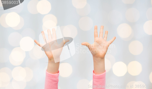 Image of close up of little child hands raised upwards