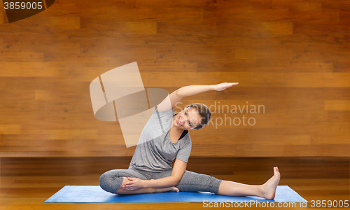 Image of happy woman making yoga and stretching on mat