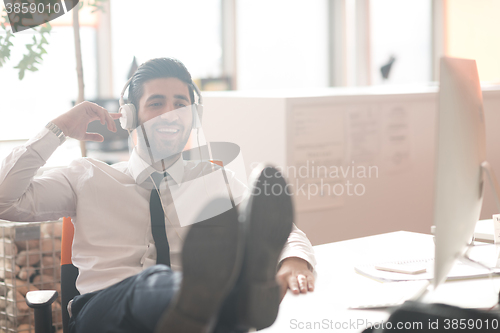 Image of relaxed young business man at office