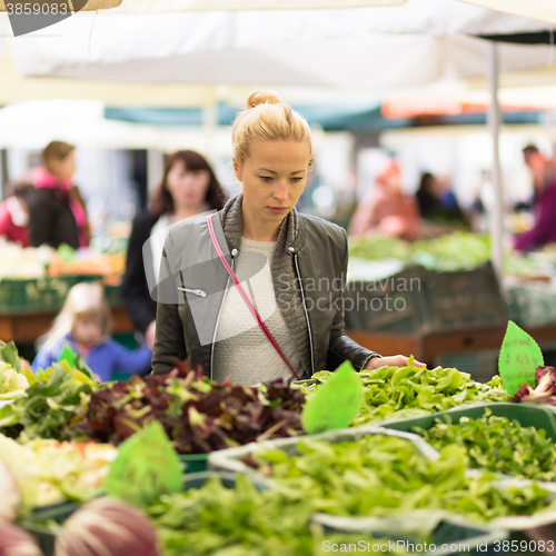 Image of Woman buying vegetable at local food market. 