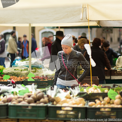 Image of Woman buying vegetable at local food market. 