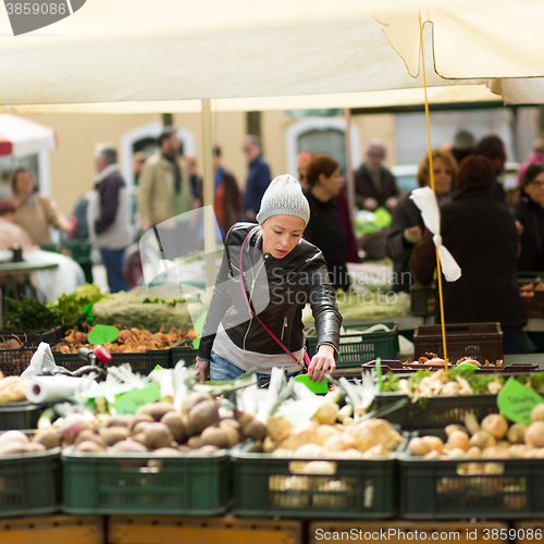 Image of Woman buying vegetable at local food market. 