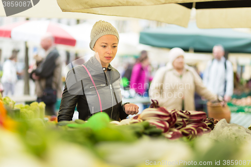 Image of Woman buying vegetable at local food market. 