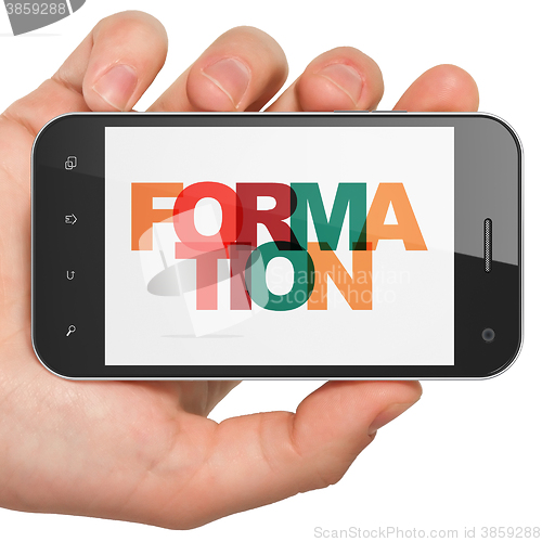 Image of Learning concept: Hand Holding Smartphone with Formation on  display