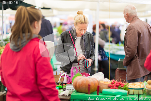 Image of Woman buying vegetable at local food market. 