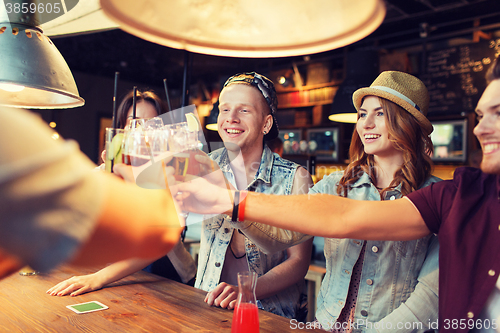 Image of happy friends drinking beer at bar or pub