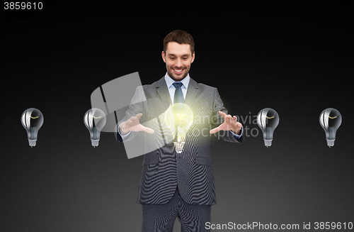 Image of businessman working with light bulb icons